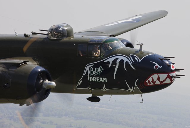 A B-25 Mitchell bomber flies in formation with dozens of other World War II era aircraft over Culpeper Regional Airport in Brandy Station, Virginia, May 7, 2015. Dozens of World War II era planes will fly past the National Mall in Washington, DC, on May 8, during the Arsenal of Democracy World War II Victory Capitol Flyover to commemorate the 70th anniversary of Victory in Europe (VE) Day. (Photo by Andrew Caballero-Reynolds/AFP Photo)