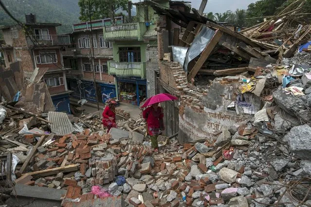 Local residents walk past collapsed houses after the April 25 earthquake, at Lamosangu village in Sindhupalchowk, Nepal, May 9, 2015. (Photo by Athit Perawongmetha/Reuters)