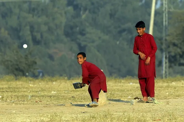 Boys plays cricket on the outskirts of Islamabad, Pakistan, Friday, November 26, 2021. (Photo by Rahmat Gul/AP Photo)