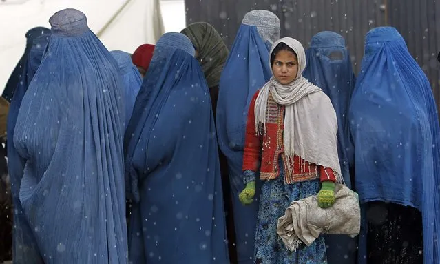 Afghan women wait to receive winter relief assistance on the outskirts of Kabul, on March 7, 2014. (Photo by Omar Sobhani/Reuters)