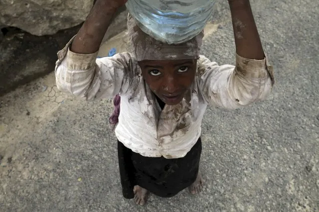 An internally displaced girl carries water on her head in the district of Khamir of Yemen's northwestern province of Amran May 9, 2015. (Photo by Mohamed al-Sayaghi/Reuters)