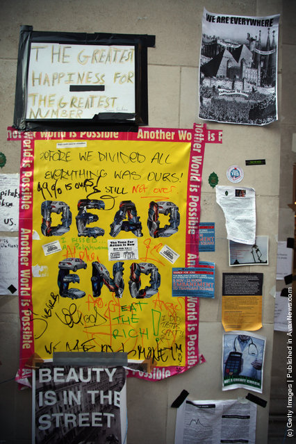 Protest posters are attached to the walls surrounding the Occupy London camp outside St. Paul's Cathedral