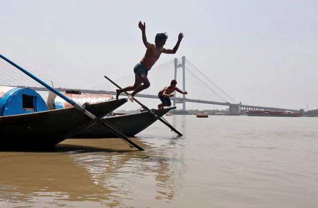 Men jump into the Ganges river to cool off on a hot summer day in Kolkata, India, April 22, 2016. (Photo by Rupak De Chowdhuri/Reuters)