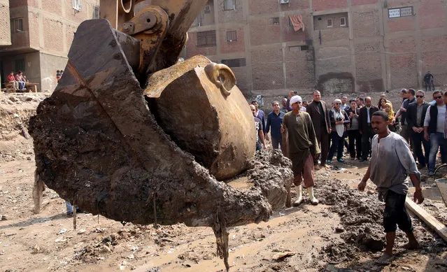 Egyptian workers lift with an excavator parts of a statue for restoration after it was unearthed at Souq al-Khamis district, at al-Matareya area, Cairo, Egypt, 09 March 2017. According to the Ministry of Antiquities, a German-Egyptian archaeological mission found in parts two 19th dynasty royal statues in the vicinity of King Ramses II temple in ancient Heliopolis. The first is an 80cm tall bust of King Seti II carved in limestone, while the second is eight meters tall carved in quartzite. There were no engravings on the latter, however discovering it at the entrance of King Ramses II temple suggests that it could belong to him. (Photo by Khaled Elfiqi/EPA)