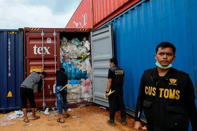 This picture taken on June 15, 2019 shows Indonesian customs officers from the local environment office examining one of 65 containers full of imported plastic rubbish, at the Batu Ampar port in Batam. Indonesia returned five other containers of rubbish to the United States and will not become a “dumping ground”, officials said on June 15, the latest Southeast Asian country to return imported waste. (Photo by Andaru/AFP Photo)