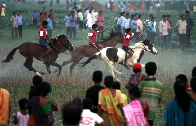 Indian boys ride horses through a vegetable field during a local horse race in Dakkhin Durgapur, about 30 kilometers south of Kolkata, India, April 5, 2014. The race is held as part of festivities to mark Sitala Puja, dedicated to the pox-Goddess Sitala. (Photo by Bikas Das/AP Photo)