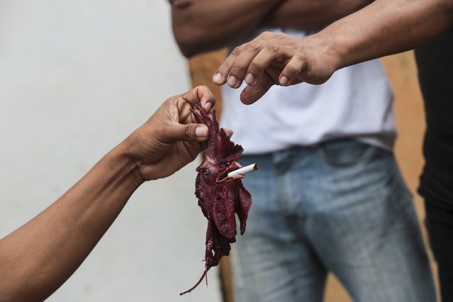 A man holds the head of a decapitated rooster after a rooster run, during celebrations in honour of San Juan Bautista in San Juan de Oriente town, Nicaragua, June 26, 2015. (Photo by Oswaldo Rivas/Reuters)