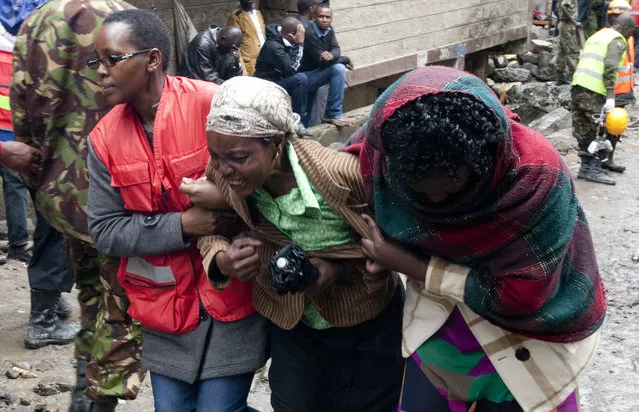 A Kenyan Red Cross personnel and a volunteer console a relative of a victim, at the site of a building collapse in Nairobi, Kenya, Saturday, April 30, 2016. A six-story residential building in a low income area of the Kenyan capital collapsed Friday night under heavy rain and flooding, killing at least seven people and injuring over 100 others, Kenyan officials said. (Photo by Sayyid Abdul Azim/AP Photo)