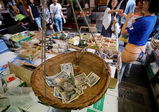 Coins and banknotes that are used for change are seen in a bamboo basket at a greengrocer in Tokyo, Japan on August 22, 2013. (Photo by Toru Hanai/Reuters)