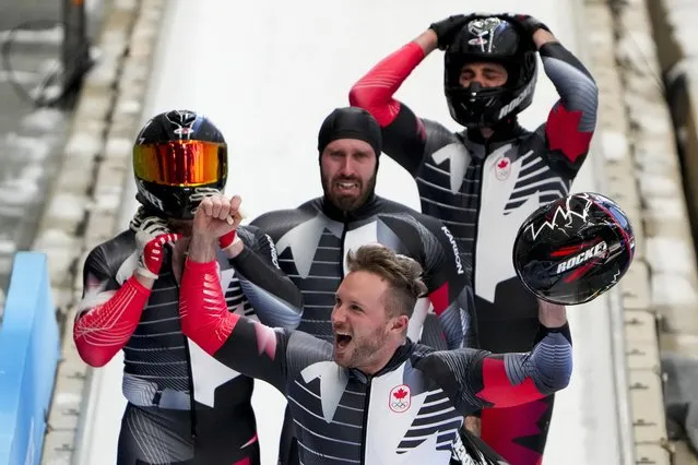 Justin Kripps, Ryan Sommer, Cam Stones and Benjamin Coakwell, of Canada, celebrate winning the bronze medal in the 4-manat the 2022 Winter Olympics, Sunday, February 20, 2022, in the Yanqing district of Beijing. (Photo by Mark Schiefelbein/AP Photo)