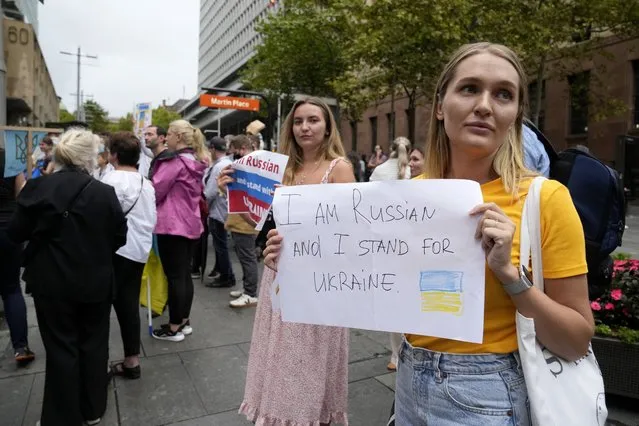 People chant, carry placards and wave Ukrainian flags as they gather in Sydney, Thursday, February 24, 2022, to demonstrate against Russian attacks in Ukraine. Russian troops launched a wide-ranging attack on Ukraine on Thursday, as President Vladimir Putin cast aside international condemnation and sanctions and warned other countries that any attempt to interfere would lead to “consequences you have never seen”. (Photo by Rick Rycroft/AP Photo)