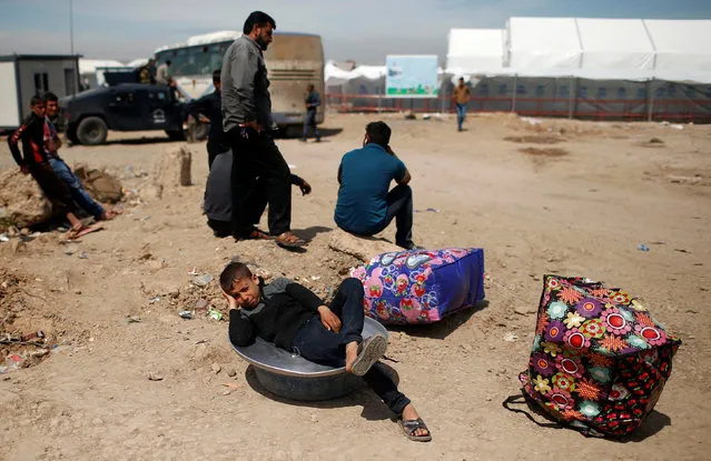 Displaced Iraqis who had fled their homes wait outside Hammam al-Alil camp south of Mosul, Iraq April 5, 2017. (Photo by Suhaib Salem/Reuters)