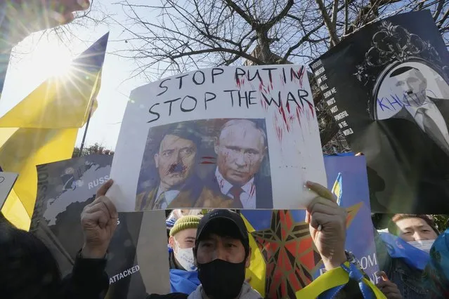 Protesters hold up their placards during a rally against Russia's invasion of Ukraine, near the Russian Embassy in Seoul, South Korea, Sunday, February 27, 2022. (Photo by Ahn Young-joon/AP Photo)