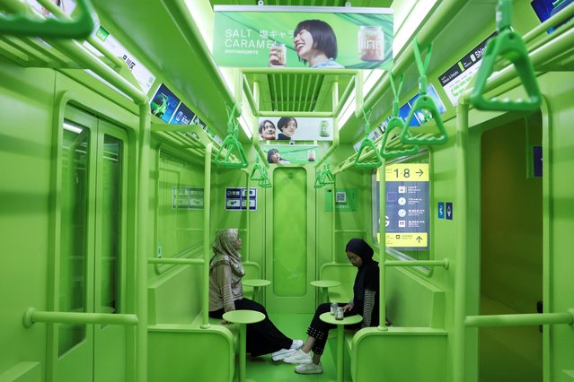 Customers sit at a cafe depicting a commuter train interior in Jakarta, Indonesia, on June 20, 2024. (Photo by Ajeng Dinar Ulfiana/Reuters)