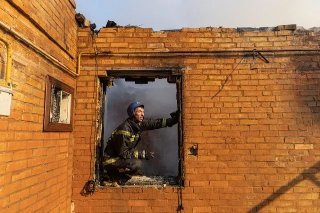 A firefighter works at a residential district that was damaged by shelling, as Russia's invasion of Ukraine continues, in Kyiv, Ukraine on March 23, 2022. (Photo by Marko Djurica/Reuters)
