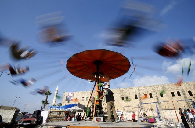People enjoy a swing ride as they celebrate tthe first day of the Muslim holiday of Eid al-Fitr, which marks the end of the holy month of Ramadan at the port-city of Sidon, southern Lebanon July 17, 2015. (Photo by Ali Hashisho/Reuters)