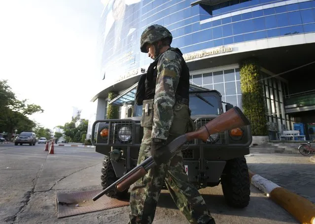 A Thai soldier walks in front of the National Broadcasting Services of Thailand television station in Bangkok May 20, 2014. Thailand's army declared martial law on Tuesday to restore order after six months of anti-government protests which have left the country without a functioning government.The declaration did not constitute a coup and was made in response to deteriorating security, an army general said. (Photo by Athit Perawongmetha/Reuters)