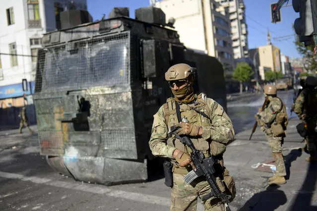 Soldiers patrol the streets of Valparaiso, Chile, Thursday, October 24, 2019. A new round of clashes broke out Thursday as demonstrators returned to the streets, dissatisfied with economic concessions announced by the government in a bid to curb a week of deadly violence. (Photo by Matias Delacroix/AP Photo)