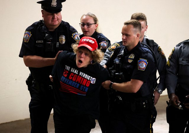 Police detain a woman during the campaign rally of Republican presidential nominee and former U.S. President Donald Trump, in Harrisburg, Pennsylvania, U.S., July 31, 2024. (Photo by Umit Bektas/Reuters)