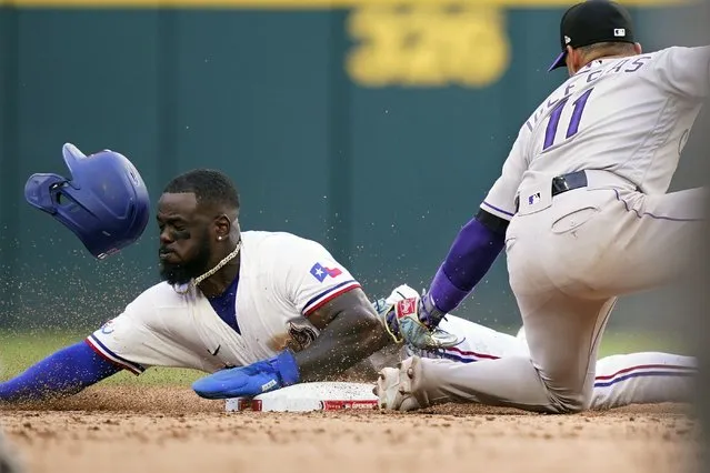 Texas Rangers' Adolis Garcia (53) is caught stealing second base against Colorado Rockies shortstop Jose Iglesias (11) during the eighth inning of a baseball ball game in Arlington, Texas, Monday, April 11, 2022. The Rockies won 6-4. (Photo by L.M. Otero/AP Photo)
