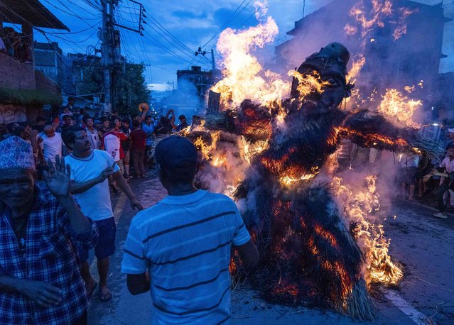 People burn an effigy of demon Ghantakarna to represent the demolition of evil during the Ghantakarna festival in Bhaktapur, Nepal, Friday, August 2, 2024. The festival is believed to ward off evil spirits, and bring peace and prosperity.(Photo by Niranjan Shrestha/AP Photo)