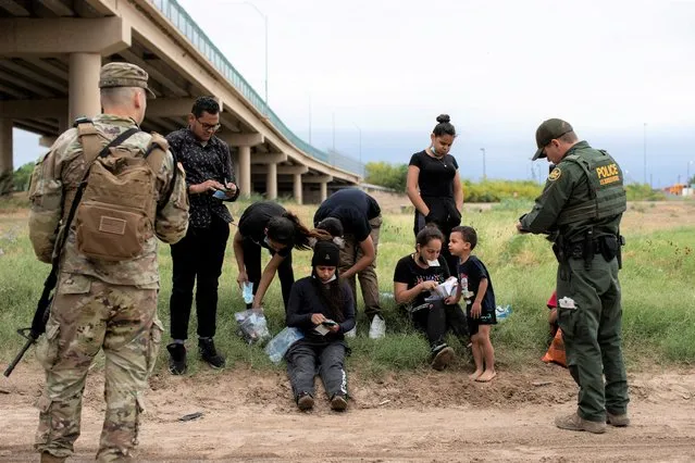 A Customs and Border Protection agent collects biographical information from a group of Venezuelan migrants before taking them into custody near the southern border town of Eagle Pass, Texas, U.S. April 25, 2022. (Photo by Kaylee Greenlee Beal/Reuters)