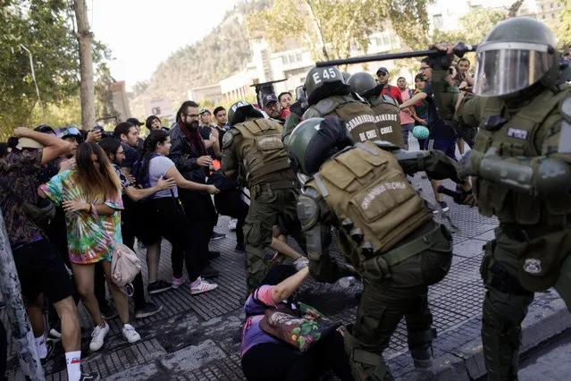 Security forces members confront demonstrators during a protest against Chile's government in Santiago, Chile on December 16, 2019. (Photo by Ricardo Moraes/Reuters)