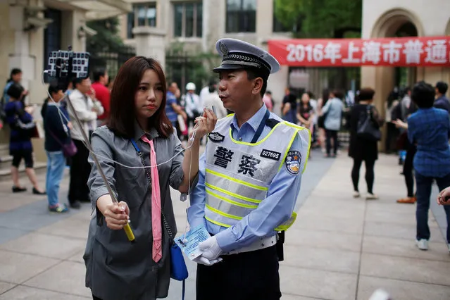 A police gives a live interview to a local media during the first part of China's annual national college entrance exam, in Shanghai, China June 7, 2016. (Photo by Aly Song/Reuters)