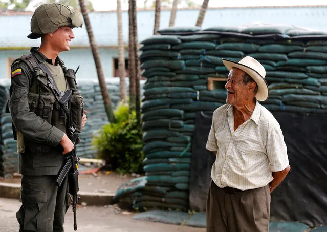 A Colombian policeman (L) talks with a resident in Lejanias, Meta province, Colombia, May 19, 2016. (Photo by John Vizcaino/Reuters)