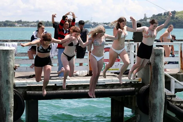 People jump into the water from the Orakei Wharf as coronavirus disease (COVID-19) lockdown restrictions are eased in Auckland, New Zealand, November 10, 2021. (Photo by Fiona Goodall/Reuters)
