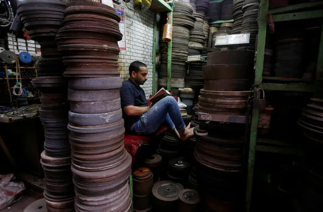 A Muslim man reads the Koran inside his shop of iron plates used in water pumps during the holy fasting month of Ramadan in the old quarters of Delhi, India June 8, 2016. (Photo by Adnan Abidi/Reuters)