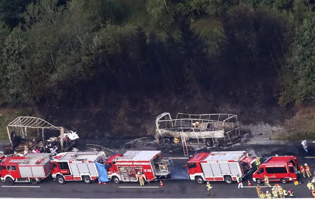 Emergency personnel work at the scene of a fatal accident on the motorway A9 near Muenchberg, Germany, Monday, July 3, 2017. A bus carrying German seniors on holiday slammed into the back of a truck that had slowed for a traffic jam and burst into flame Monday, authorities said. (Photo by Bodo Schackow/DPA via AP Photo)