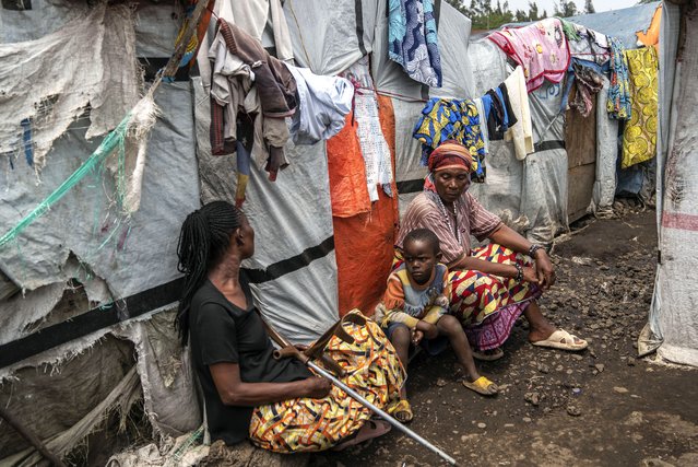 People sit at the Don Bosco refugee camp as Red Cross officials create awareness around mpox in Goma, Democratic Republic of Congo, Thursday, August 22, 2023. (Photo by Moses Sawasawa/AP Photo)