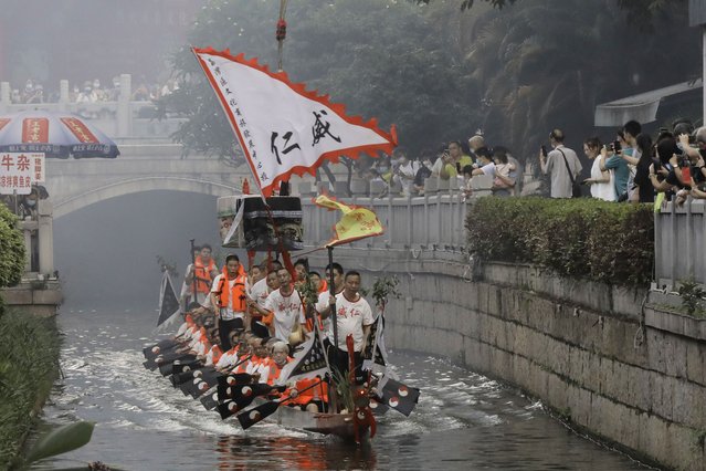 Dragon boat participants from Panting village row along a canal in the historic Lychee Bay scenic area in Guangzhou in southern China's Guangdong Province, Friday, June 3, 2022. Dragon boat races returned in parts of China on Friday for the first time since the outbreak of the pandemic in late 2019, as restrictions are lifted along with a major drop in COVID-19 cases. The historic Lychee Bay scenic area in the southern Chinese manufacturing hub of Guangzhou staged races and other scaled-back celebrations to mark the holiday that commemorates the death more than 2,200 years ago of revered poet and government minister Qu Yuan. (Photo by Caroline Chen/AP Photo)
