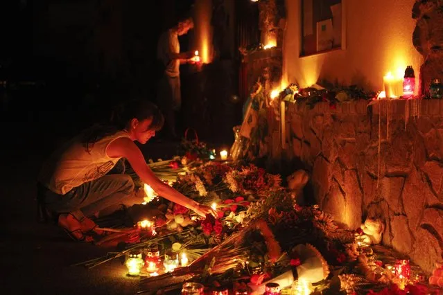 People light candles at the Malaysian embassy for victims of Malaysia Airlines MH17, which crashed in eastern Ukraine, in Kiev July 17, 2014. The Malaysia Airlines Boeing 777, flying from Amsterdam to Kuala Lumpur, was brought down in eastern Ukraine on Thursday, killing all 295 people aboard and sharply raising the stakes in a conflict between Kiev and pro-Moscow rebels. (Photo by Valentyn Ogirenko/Reuters)