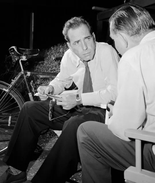 Humphrey Bogart, star of “conflict”, conversing between takes while his bicycle close at hand for a fast getaway when lunch call is given in Hollywood on July 8, 1945. Person at right unidentified. (Photo by AP Photo)