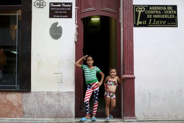 Dianet Tamayo, 10, (L), poses for a photo with Carolina Fernanda Alvarez, 5, at the doorstep of her home in downtown Havana, July 21, 2015. (Photo by Alexandre Meneghini/Reuters)
