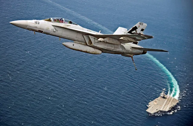 An F/A-18F Super Hornet jet flies over the USS Gerald R. Ford as the U.S. Navy aircraft carrier tests its EMALS magnetic launching system, which replaces the steam catapult, and new AAG arrested landing system in the Atlantic Ocean July 28, 2017. (Photo by Erik Hildebrandt/Reuters/U.S. Navy)