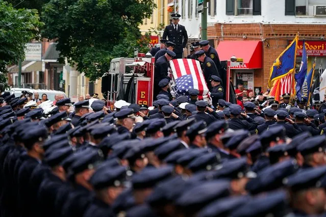 The remains of Lt. Sean Williamson, a 27-year veteran of the Philadelphia Fire Department, are brought to Epiphany of Our Lord Catholic Church for funeral mass in Philadelphia, Monday, June 27, 2022. Williamson was killed in an early morning building collapse on June 18. He was 51. (Photo by Matt Rourke/AP Photo)