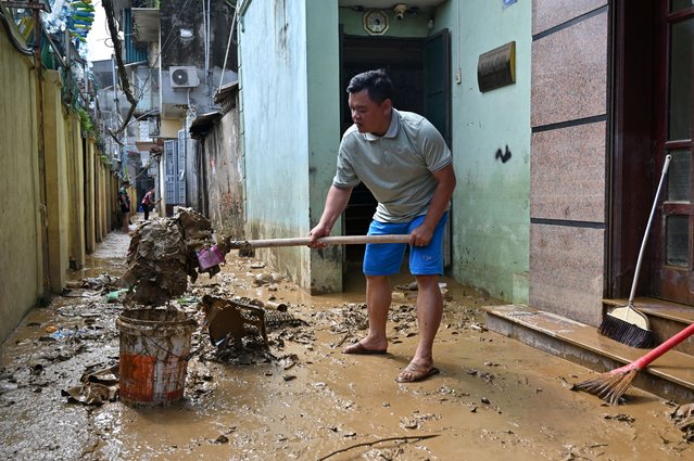 A resident cleans up muddy debris after flood waters receded in Hanoi on September 13, 2024. Typhoon Yagi brought a colossal deluge of rain that has inundated a swathe of northern Vietnam, Laos, Thailand and Myanmar, triggering deadly landslides and widespread river flooding. (Photo by Nhac Nguyen/AFP Photo)