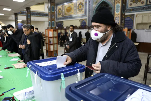 A voter casts his ballot in the parliamentary elections in a polling station in Tehran, Iran, Friday, February 21, 2020. Iranians began voting for a new parliament Friday, with turnout seen as a key measure of support for Iran's leadership as sanctions weigh on the economy and isolate the country diplomatically. (Photo by Vahid Salemi/AP Photo)