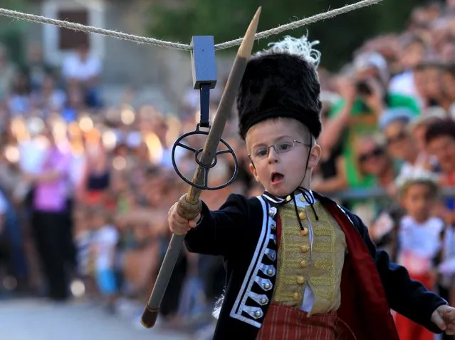 A child runs during the Children's Alka competition in Vuckovici village, Croatia, August 23, 2015. (Photo by Antonio Bronic/Reuters)