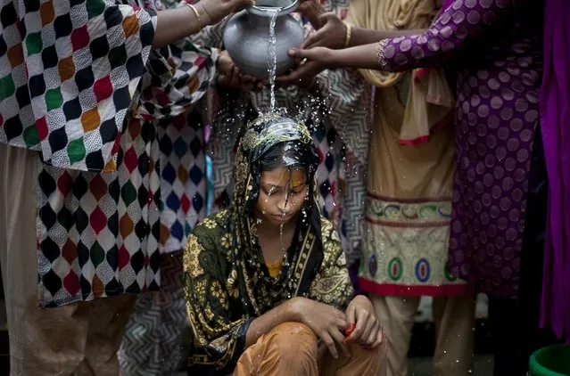 Nasoin Akhter, 15, is bathed on the day of her wedding to a 32-year-old man, August 20, 2015, in Manikganj, Bangladesh. (Photo by Allison Joyce/Getty Images)