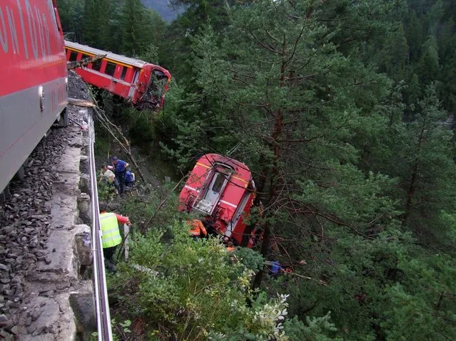 Police and rescue workers help after a passenger train derailed into a ravine near Tiefencastel in a mountainous region of southeastern Switzerland after encountering a mudslide on the tracks August 13, 2014. Several passengers were injured after at least three train carriages came off the tracks near Tiefencastel, a village less than 50 km (31 miles) northwest of the ski resort St. Moritz. (Photo by Kantonspolizei Graubunden/Reuters)