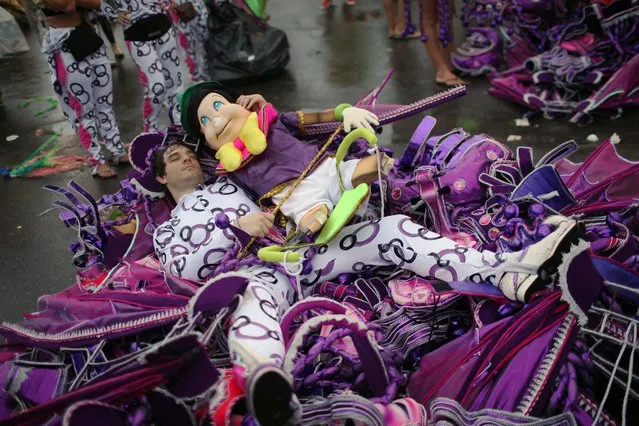 A samba school dancer rests after a carnival parade at the Sambadrome in Rio de Janeiro, Brazil, early Monday March 7, 2011. (Photo by Rodrigo Abd/AP Photo)