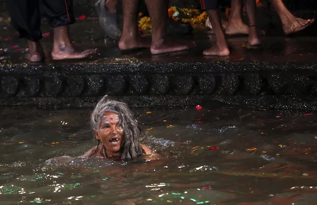 A Hindu holy woman bathes in the Godavari River during Kumbh Mela, or Pitcher Festival, at Trimbakeshwar in Nasik, India, Saturday, August 29, 2015. (Photo by Rajanish Kakade/AP Photo)