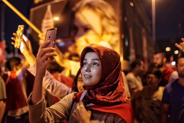 A supporter of Turkish President Tayyip Erdogan takes a selfie as people gather in Istanbul's central Taksim Square on July 18, 2016 in Istanbul, Turkey. Clean up operations are continuing in the aftermath of Friday's failed military coup attempt which claimed the lives of more than 232 people. In raids across Turkey 7,543 people have been arrested in relation to the failed coup including high-ranking soldiers and judges, Turkey's PM Binali Yildirim has said. (Photo by Kursat Bayhan/Getty Images)
