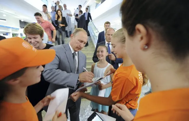 Russian President Vladimir Putin (C) signs autographs as he meets with students at the Sirius educational centre for gifted children in Sochi, Russia, September 1, 2015. (Photo by Mikhail Klimentyev/Reuters/RIA Novosti/Kremlin)