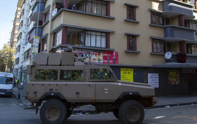 Residents stand on a balcony as a South African National Defence Forces vehicle patrol the street, in Johannesburg, South Africa, Tuesday, April 7, 2020. South Africa and more than half of Africa's 54 countries have imposed lockdowns, curfews, travel bans or other restrictions to try to contain the spread of COVID-19. (Photo by Themba Hadebe/AP Photo)