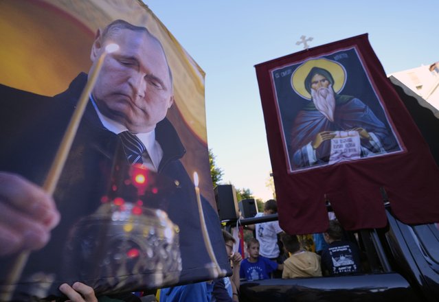 People hold icons and a picture of Russian President Vladimir Putin during a protest against the international LGBT event Euro Pride in Belgrade, Serbia, Sunday, September 11, 2022. Thousands of opponents of a pan-European LGBTQ event planned for this week in Belgrade marched through the Serbian capital on Sunday despite an announced ban of Europe's largest annual gay gathering. (Photo by Darko Vojinovic/AP Photo)